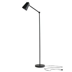 a floor lamp with a black shade on the base and a cord attached to it