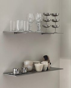 two shelves with glasses, cups and bowls on them