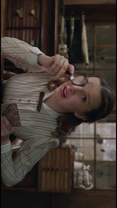 a woman with glasses is brushing her teeth