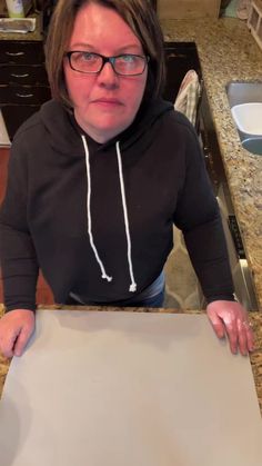 a woman sitting at a table with a piece of paper in front of her