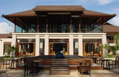 an outdoor dining area in front of a large building with tables and chairs around it