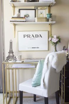 a white chair sitting in front of a desk with books on it and a lamp