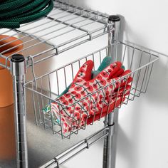 a pair of red slippers sitting in a wire basket on a shelf next to other items