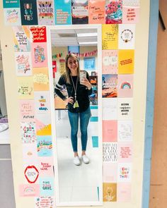 a woman standing in front of a mirror covered in papers and magnets on the wall