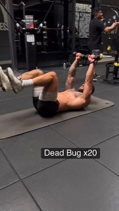 a man is doing push ups on a mat in the middle of a crossfit gym