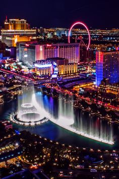 the las vegas strip is lit up at night with colorful lights and fountains in the water