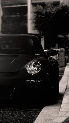 a black sports car is parked on the side of the road