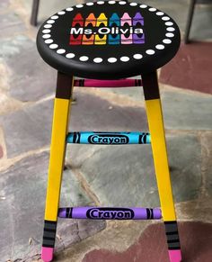 a child's wooden stool with crayons on it