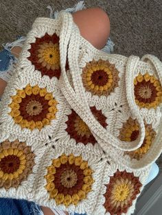 a crocheted bag with sunflowers on it is sitting on the floor