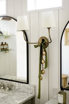 a bathroom with two lights and a mirror on the wall next to a counter top