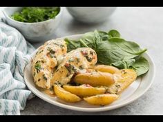 a white plate topped with french fries covered in cheese and spinach next to a bowl of greens