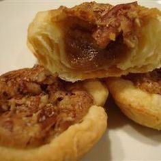 three pastries sitting on top of each other on a white plate next to a fork