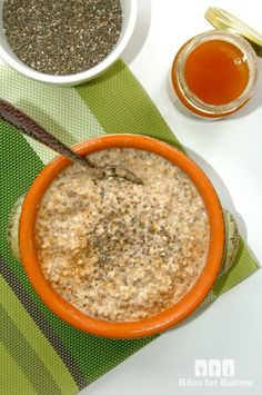 an orange bowl filled with oatmeal sitting on top of a green napkin