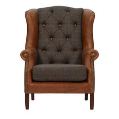 a brown leather and tweed chair with buttons on the back, sitting against a white background