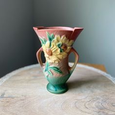 a vase sitting on top of a wooden table