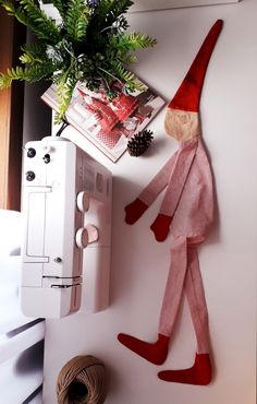 an elf is hanging on the wall next to a sewing machine