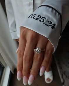 a close up of a person's hand with a ring on their finger and nails