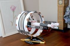 a model of a star trek ship on a wooden table next to a clock and flowers