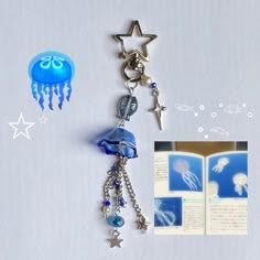 an open book with charms attached to it next to a jellyfish and star charm