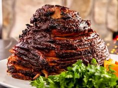 a large piece of meat sitting on top of a white plate next to some vegetables