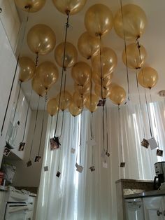 gold balloons hanging from the ceiling in a kitchen