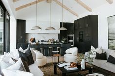 a living room filled with lots of furniture next to a kitchen and dining room table