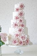 a three tiered cake with pink roses on it