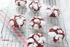 red velvet cookies on a cooling rack covered in powdered sugar