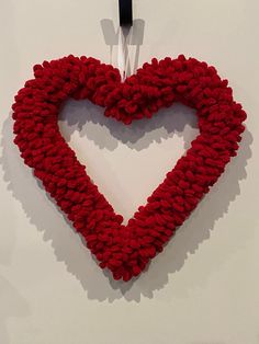 a knitted heart hanging on a wall