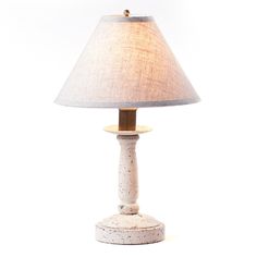 a table lamp with a white base and a light shade on it's side