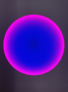 a blue and pink circular object on a black background