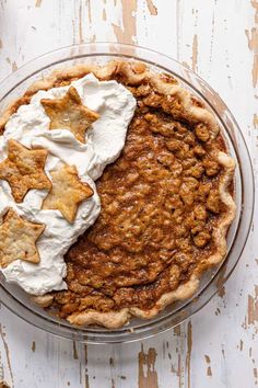 an apple pie with whipped cream and star shaped crackers in the crust on top