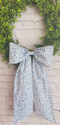 a blue and white bow hanging on a brick wall