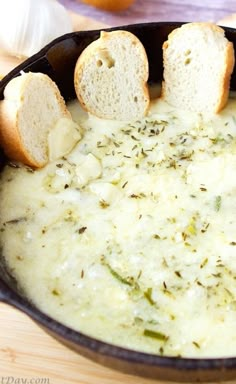 bread sticks sticking out of a skillet filled with cream cheese dip on a cutting board