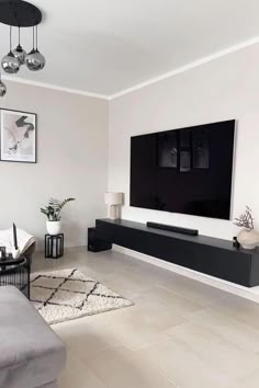 a large flat screen tv mounted on the wall in a living room next to a couch