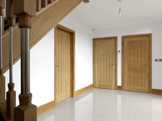 an empty room with wooden doors and white floors