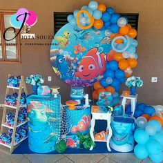 an under the sea themed birthday party with balloons, decorations and tableware on display