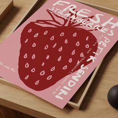 a strawberry poster sitting on top of a wooden table