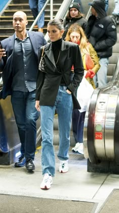 two people are walking down an escalator