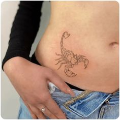 a woman's stomach with a scorpion tattoo on her belly and the word love written in cursive writing