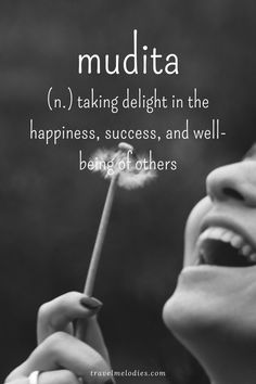 a woman holding a dandelion with the words mudita on it