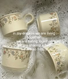 three coffee cups sitting on top of a table next to each other with the words in my dreams we are living together, we are eating together