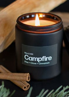 a candle that is sitting next to some cinnamons