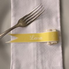 a fork and napkin with a name tag on it next to a knife and fork