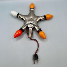 an orange and white light is attached to a star shaped object with two red lights