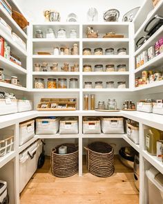 an organized pantry with white shelves and baskets