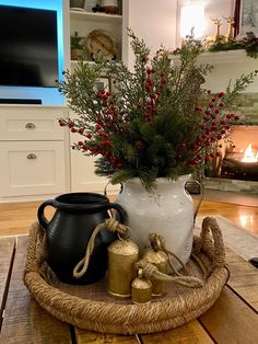 a white pitcher sitting on top of a wooden table next to a potted plant