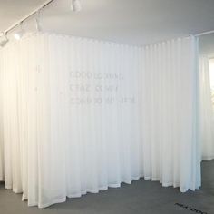 an empty room with white curtains and writing on the wall