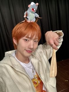 a person with an animal on top of their head and a spoon in his hand