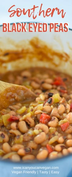 a bowl filled with beans and vegetables next to a wooden spoon